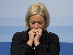 FILE - In this Friday Jan. 29, 2016, file photo Defense Minister Jeanine Hennis-Plasschaert reacts to a loud crackling sound from the microphone amplifier when explaining the cabinet decision to extend its campaign of Dutch air strikes from Iraq into Eastern Syria during a press conference in The Hague. The Dutch caretaker defense minister and the Netherlands' military chief have resigned following a critical report into a 2016 artillery training accident that killed 2 peacekeeping troops. (AP Photo/Peter Dejong, File)