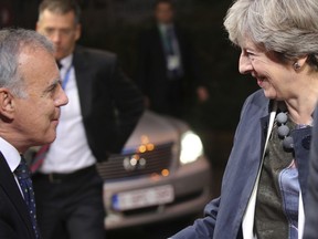 British Prime Minister Theresa May, right, is greeted when arriving for an EU summit in Brussels on Friday, Oct. 20, 2017. European Union leaders conclude a two day summit on Friday in which they discussed migration, digital economy and Brexit. (AP Photo/Olivier Matthys)