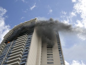 FILE - In this July 14, 2017, file photo, smoke billows from the upper floors of the Marco Polo apartment complex in Honolulu. Officials in Honolulu plan to release the investigation into the deadly fire that killed three residents of the 36-story apartment building. (AP Photo/Marco Garcia, file)