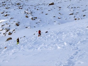 In this Monday, Oct. 9, 2017, photo provided by the The Gallatin National Forest Avalanche Center, searchers probe the lower portion of an avalanche debris field for a missing skier on Imp Peak in the southern Madison Range in southwestern Montana. A woman's body was recovered after two skiers triggered the weekend avalanche that fully buried the woman and partially buried a man. (The Gallatin National Forest Avalanche Center via AP)
