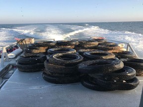 This Oct. 12, 2017, photo provided by the California Coastal Commission/UC Davis shows a pile of scrap tires after they were pulled out of the water off Balboa Peninsula in Newport Beach, Calif. Divers are removing hundreds of old tires, plastic jugs and other junk that were dumped off the Southern California coast nearly 30 years ago in hopes of creating an artificial reef that would serve as a home to fish and mussels. (California Coastal Commission/UC Davis via AP)