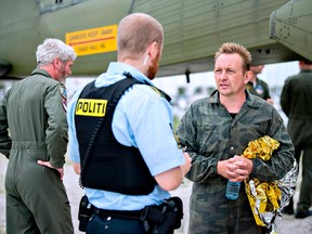 Peter Madsen, builder and captain of the private submarine "UC3 Nautilus," talks to a police officer in Dragoer Harbour, south of Copenhagen, on Aug. 11, 2017.