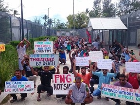 In this undated photo released by Refugee Action Coalition, refugees and asylum seekers hold up banners during a protest at the Manus Island immigration detention centre in Papua New Guinea. As Australia moved to close a detention center for asylum seekers it won't allow on its shores, Papua New Guinea's government warned the 600 men who want to stay at the Manus Island facility they may be removed if they stay beyond a Tuesday, Oct. 31, 2017 deadline. (Refugee Action Coalition via AP)