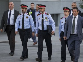 Catalan regional police chief Josep Luis Trapero, centre, arrives at the national court in Madrid, Spain, Friday, Oct. 6, 2017. A Spanish judge is due to question Mossos d'Esquadra chief Trapero and two pro-independence campaigners about their role in an Oct. 1 referendum that the Spanish government declared as illegal. (AP Photo/Paul White)