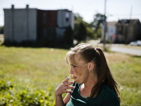 In this Wednesday, Oct. 4, 2017 photo, Denise Brown who is addicted to heroin, smokes as after she picked up a package of necessities from the Camden Area Health Education Center Mobile Health Van parked in vacant lot in Camden, N.J. Advocates say the shuttering of a needle exchange in Camden has left many in a city notorious for heroin without a resource that has handed out thousands of sterile syringes. (AP Photo/Matt Rourke)