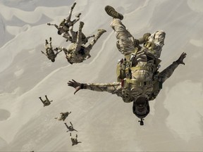 In this Aug. 21, 2017 photo released by the U.S. Defense Department, Qatari special operations personnel conduct a military free-fall Friendship Jump over Qatar. The U.S. military has halted some exercises with its Gulf Arab allies over the ongoing diplomatic crisis targeting Qatar,  trying to use its influence to end the monthslong dispute, authorities told The Associated Press on Friday, Oct. 6, 2017. (Staff Sgt. Trevor T. McBride/ U.S. Air Force via AP)