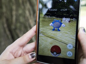 Mary Baker, 18, plays the mobile game Pokemon Go as she walks through the Public Garden in Boston, Mass., July 11, 2016.