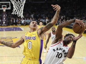 DeMar DeRozan, right, of the Toronto Raptors battles Kyle Kuzma of the Los Angeles Lakers to grab a rebound during NBA action Friday night in Los Angeles. DeRozan had a game high 24 points in Toronto's 101-92 victory.