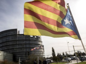 A demonstrator waves a Catalan flag in support of the disputed independence vote Sunday in Catalonia during a protest in front of the European Parliament in Strasbourg, eastern France, Wednesday, Oct. 4, 2017. European Commission Vice President Frans Timmermans says there is a "general consensus that regional government of Catalonia has chosen to ignore the law when organizing the referendum." (AP Photo/Jean-Francois Badias)