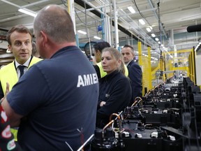 French President Emmanuel Macron talks with Whirlpool employees during a visit at the company's factory in Amiens, France, Tuesday, Oct. 3, 2017. Macron visits an ailing Whirlpool dryer factory in northern France that was the site of a pivotal moment in his presidential campaign, when he debated with angry workers about his strategy to stop job losses. (Philippe Wojazer/Pool Photo via AP)