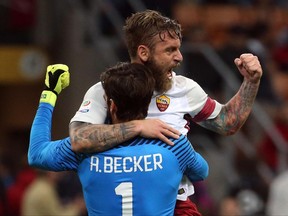 Roma goalkeeper Alisson Becker and teammate Daniele De Rossi celebrate their side's 2-0 win at the end of the Serie A soccer match between AC Milan and Roma, at the Milan San Siro stadium, Italy, Sunday, Oct. 1, 2017. (Matteo Bazzi/ANSA via AP)