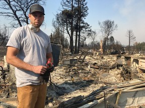 Resident Ryan Nelson goes through the ruins of his house to try to find his grandfather's rifles in Santa Rosa, Calif., Wednesday, Oct. 11, 2017. As his house filled with smoke from one of California's devastating wine country fires, Nelson's thoughts went to his elderly neighbors, one of whom has multiple sclerosis. He ran over and pounded on their doors and windows, but wasn't able to get their attention. Now he fears they didn't make it out and wonders whether he could have done more to help. (AP Photo/Jonathan Copper)