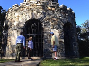 In this Friday, Sept. 29, 2017 photo, Jack Monahan, member of the U.S. World War I Centennial Commission, left, views a World War I memorial, which was vandalized about 40 years ago, with Bob Cornett, right, and Edith Fletcher, center, at Miantonomi Memorial Park Tower in Newport, R.I. The tower once featured bronze plaques with the names of WWI soldiers from the area who perished. The centennial of America's involvement in World War I has drawn attention to the state of disrepair of many monuments honoring soldiers, galvanizing efforts to fix them. (AP Photo/Jennifer McDermott)