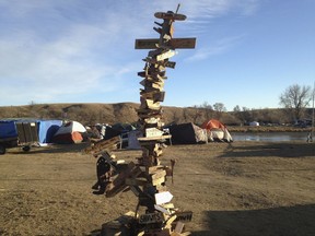 This Nov. 26, 2016, photo shows a mile-marker post created by activists near Cannon Ball, N.D., during protests against the Dakota Access pipeline. The Smithsonian Institution's National Museum of the American Indian in Washington, D.C., is adding the 12-foot-tall marker to its exhibit on treaties called "Nation to Nation: Treaties Between the United States and American Indian Nations." (AP Photo/James MacPherson)