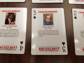 Playing cards featuring unsolved and unidentified homicides or missing person cases are displayed at Oklahoma State Bureau of Investigation headquarters in Oklahoma City, Wednesday, Oct. 11, 2017. Oklahoma State Bureau of Investigation Director and Oklahoma Department of Correction Director have joined to sell the playing cards to the state prison inmates.  (AP Photo/Ken Miller)