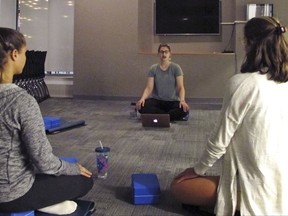 In this Sept. 12, 2017 photograph, students at the University of Vermont in Burlington, Vt., take a meditation class in a new Wellness Environment dormitory. The university has opened a dorm that goes beyond mere bans on drugs and alcohol to promote overall healthy lifestyles. Students meditate, practice yoga, eat well and make other healthy choices in the Wellness Environment. (AP Photo/Lisa Rathke)