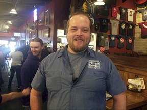 Nick Atchison who is a bartender at the Russian River Brewery poses for a photo Friday, Oct. 13, 2017, in Santa Rosa, Calif. Maker of the popular Pliny the Elder and Pliny the Younger beers, the brewery closed for just one day after wildfires ripped through the city's northern edge, part of a series of wind-whipped blazes north of San Francisco that quickly became the deadliest in state history. After the fires, the brewery which reopened Tuesday turned into an ad hoc community center where people gathered to exchange news. (AP Photo/Paul Elias)