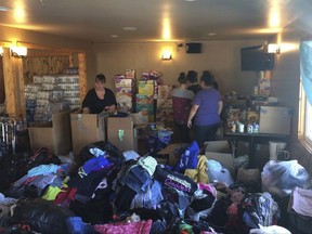 Redwood Valley residents sort through donations and supplies at McCarty's Bar, which turned into an evacuation center in Redwood Valley, Calif., Saturday, Oct. 14, 2017. Mendocino County is 70 miles north of California's fabled wine country now under siege from wildfires but a world away in mood, attitude and, especially, prominence. That helps explain why some residents feel ignored as they deal with catastrophic wildfires, just like their better-known neighbors to the south. (AP Photo/Paul Elias)