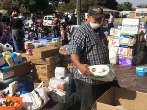 FILE -- In this Oct. 17, 2017 file photo wildfire evacuee Gonzalo Jauregui, a local grape picker, browses through donated toiletries at the Sonoma-Marin Fairgrounds in Petaluma, Calif. The deadliest and most destructive wildfires in California history imperiled both the low-wage workers who harvest the nation's most valuable wine grapes and the wealthy entrepreneurs who employ them. (AP Photo/Olga R. Rodriguez,file)