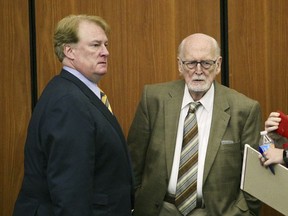 FILE - In a May 23, 2017 file photo, former Majority Leader Rick Quinn, left, and his father, Richard Quinn Sr. pause as they talk during a break in a hearing to get solicitor David Pascoe disqualified from the prosecution of Quinn in Columbia, S.C. Solicitor David Pascoe announced Wednesday, Oct. 18, that the State Grand Jury had returned indictments against Richard Quinn on charges of criminal conspiracy and failure to register as a lobbyist. Grand jurors also issued new indictments for two lawmakers already charged. Rep. Rick Quinn, the elder Quinn's son, was charged with criminal conspiracy. (Tim Dominick/The State via AP)