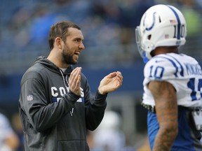 Injured Indianapolis Colts quarterback Andrew Luck, left, stands near wide receiver Donte Moncrief, right, during warmups before an NFL football game against the Seattle Seahawks, Sunday, Oct. 1, 2017, in Seattle. (AP Photo/Stephen Brashear)