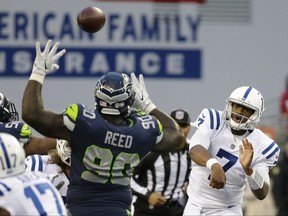 Indianapolis Colts quarterback Jacoby Brissett (7) passes under pressure from Seattle Seahawks defensive tackle Jarran Reed (90), in the first half of an NFL football game, Sunday, Oct. 1, 2017, in Seattle. (AP Photo/Elaine Thompson)
