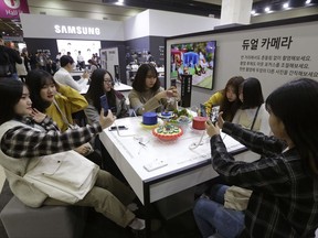 College students experience Samsung Electronics' Galaxy Note 8 smartphones during the 2017 Korea Electronics Grand Fairs in Seoul, South Korea, Tuesday, Oct. 17, 2017. The environmental group Greenpeace issued a report on Tuesday giving technology titans like Samsung Electronics, Amazon and Huawei low marks for their environmental impact. (AP Photo/Ahn Young-joon)