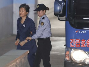 Former South Korean President Park Geun-hye, left, arrives for her trial at the Seoul Central District Court in Seoul, South Korea, Monday, Oct. 16, 2017. Lawyers for jailed Park have resigned in an apparent protest against a court decision to extend her detention. (Choi Jun-seok/Newsis via AP)