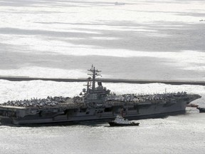 The aircraft carrier USS Ronald Reagan (CVN 76) is escorted into Busan port, South Korea, after completing a joint drill with the South Korean military, Saturday, Oct. 21, 2017. U.S. naval commanders on Saturday reiterated Washington's "ironclad" commitment to defend South Korea against North Korean threats as the American nuclear-powered aircraft carrier visited a South Korean port following a joint naval drill. (Jo Jung-ho/Yonhap via AP)