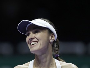 Martina Hingis of Switzerland enters the court as she pairs up with Chan Yung-Jan of Taiwan during their doubles semifinal match against Timea Babos of Hungary and Andrea Hlavackova of the Czech Republic at the WTA tennis tournament in Singapore, on Saturday, Oct. 28, 2017. (AP Photo/Yong Teck Lim)