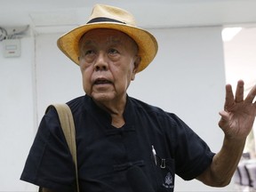 Thai social critic Sulak Sivaraksa talks to reporters at a police station before going to Bangkok military court in Bangkok, Thailand, Monday, Oct. 9, 2017. Sulak faces up to 15 years in prison for offending the monarchy after questioning whether a duel on elephant-back, fought more than 400 years ago by a Thai king against a Burmese adversary, ever took place. (AP Photo/Sakchai Lalit)