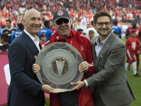 Toronto FC president Bill Manning (left), MLSE chairman Larry Tanenbaum and TFC GM Tim Bezbatchenko pose with the Supporters' Shield on Oct. 15, 2017. (THE CANADIAN PRESS)