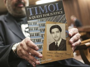 In this Thursday, Aug. 24, 2017 file photo, Imtiaz Cajee, nephew of Ahmed Timol, poses with his book "Timol, A Quest for Justice" in the North Gauteng High court in Pretoria, South Africa