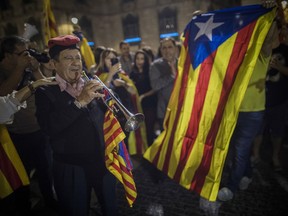 People gather in front of the Palau Generalitat in Barcelona, Spain awaiting for Catalan President Carles Puigdemont's speech Saturday, Oct. 21, 2017. Spain announced an unprecedented plan Saturday to sack Catalonia's separatist leaders, install its own people in their place and call a new local election, using previously untapped constitutional powers to take control of the prosperous region that is threatening to secede. (AP Photo/Santi Palacios)