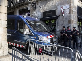 Armed officers from the Mossos d'Esquadra regional police force stand guard at an entrance to Sant Jaume square near the Generalitat regional government offices in Barcelona, Spain, on Monday, Oct. 30, 2017.