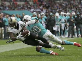 New Orleans Saints wide receiver Michael Thomas, left, scores a touchdown against Miami Dolphins cornerback Cordrea Tankersley (30) during the second half of an NFL football game at Wembley Stadium in London, Sunday Oct. 1, 2017. (AP Photo/Tim Ireland)