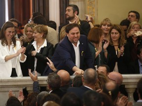 Catalan Vice President Oriol Junqueras, center, is greeted after a vote on independence in the Catalan parliament in Barcelona, Spain, Friday, Oct. 27, 2017. Catalonia's regional parliament passed a motion with which they say they are establishing an independent Catalan Republic. (AP Photo/Manu Fernandez)
