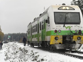 A police officer walks alongside a train that was involved in a crash with a military truck in which several people were killed in southern Finland Thursday Oct. 26, 2017.  Finnish media say several people have been killed in a train crash in the southern part of Finland. (Lehtikuva via AP)
