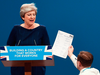 Protester/comedian Simon Brodkin gives a mock dismissal form to British Prime Minister Theresa May.