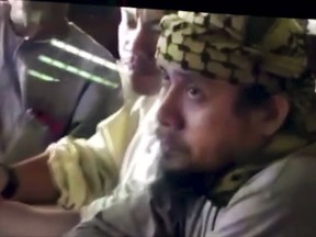 FILE - This file image taken from undated video shown to The Associated Press by the Philippine military shows the purported leader of the Islamic State group Southeast Asia branch, Isnilon Hapilon, right, at a meeting of militants at an undisclosed location. Philippine security officials told The Associated Press that Isnilon Hapilon, who is listed among the FBI's most-wanted terror suspects, and Omarkhayam Maute were killed in a gunbattle and their bodies were found Monday, Oct. 16, 2017 in Marawi. (Philippines Military via AP, File)