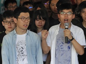 FILE - In this Aug. 17, 2017 file photo, Hong Kong activist Joshua Wong, right, and Nathan Law, left, speak outside the high court before a ruling on a prosecution request for stiffer sentences following a lower court decision that let them avoid prison in Hong Kong. Hong Kong's highest court on Tuesday, Oct. 24, 2017 has freed pro-democracy activists Joshua Wong and Nathan Law on bail pending an appeal of their prison sentences after they were convicted of sparking massive protests in 2014. (AP Photo/Vincent Yu, File)