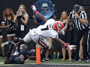 Georgia running back D'Andre Swift (7) reaches past Vanderbilt safety Ryan White to score a touchdown on a 5-yard pass reception in the first half of an NCAA college football game Saturday, Oct. 7, 2017, in Nashville, Tenn. (AP Photo/Mark Humphrey)