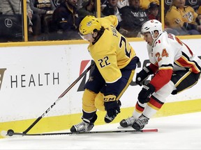 Calgary Flames defenseman Travis Hamonic (24) loses his stick as he follows Nashville Predators left wing Kevin Fiala (22), of Switzerland, in the second period of an NHL hockey game Tuesday, Oct. 24, 2017, in Nashville, Tenn. (AP Photo/Mark Humphrey)