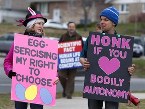 Pro-choice group Love Team Peterborough march carrying bright pink signs alongside the Peterborough Pro-Life group outside Peterborough Regional Health Centre (PRHC) on Saturday April 15, 2017 in Peterborough, Ont.