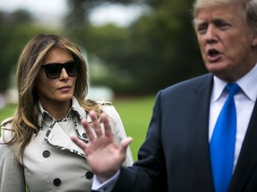 First Lady Melania Trump, left, listens as U.S. President Donald Trump speaks to members of the media before boarding Marine One on the South Lawn of the White House in Washington, D.C., U.S., on Friday, Oct. 13, 2017.