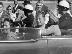 In this Nov. 22, 1963 file photo, President John F. Kennedy waves from his car in a motorcade in Dallas.