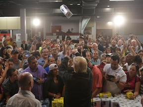 US President Donald Trump throws a paper towel roll as he visits the Cavalry Chapel in Guaynabo, Puerto Rico on October 3, 2017.