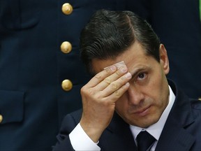 FILE - In this Sept. 7, 2017 file photo, Mexico's President Enrique Pena Nieto wipes sweat from his forehead during the International Financial Inclusion Forum at the National Palace in Mexico City. In a letter published Tuesday, Oct. 24, Pena Nieto's office is acknowledging that he met several times with officials of  Odebrecht, a Brazilian construction firm that has admitted paying bribes throughout Latin America, but the office denies any wrongdoing. (AP Photo/Marco Ugarte, File)