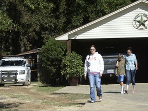 Family of those who were killed in a house fire make their way from a home in Silsbee, Texas, Wednesday, Oct. 18, 2017. A woman and her children were killed in a fire that quickly engulfed their Texas home, authorities said Wednesday. (Kim Brent/The Beaumont Enterprise via AP)