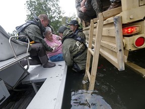 FILE - In this Aug. 30, 2017, file photo, members of the Louisiana Department of Wildlife and Fisheries, the Florida Fish and Wildlife Conservation Commission, and the Louisiana National Guard help rescue an elderly resident from the Golden Years Assisted Living home, which was flooded from Tropical Storm Harvey in Orange, Texas. Deaths at nursing home facilities in Texas and Florida after recent hurricanes made landfall have left families of residents, law enforcement officials and state regulators questioning evacuation decisions. Experts on aging say the risk of illness and death increases for elderly residents who are evacuated and advocate for a patient-by-patient risk assessment system in the future. (AP Photo/Gerald Herbert, File)